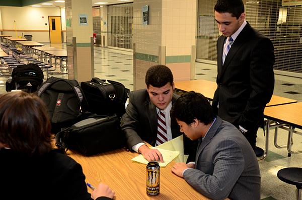 Seniors Berryman Toler, Emir Humzah and junior Faysal Anis discuss their notes for the next debate round. The Debate team placed in the top eight at District. Photo by Mubarrat Choudhury