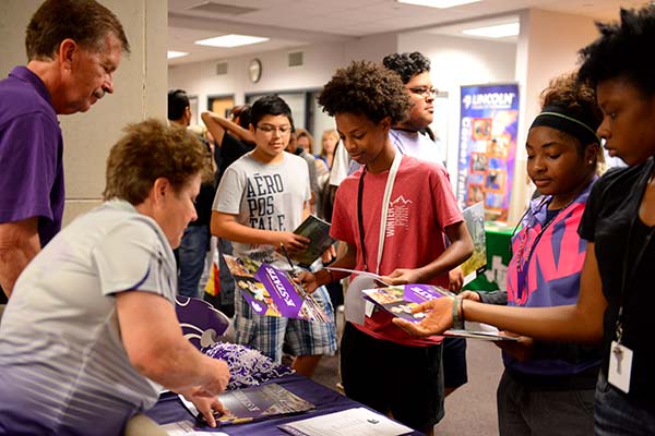 Students crowd around the Kansas State University table to learn more information regarding the university. Photo by Fidelia Nawar