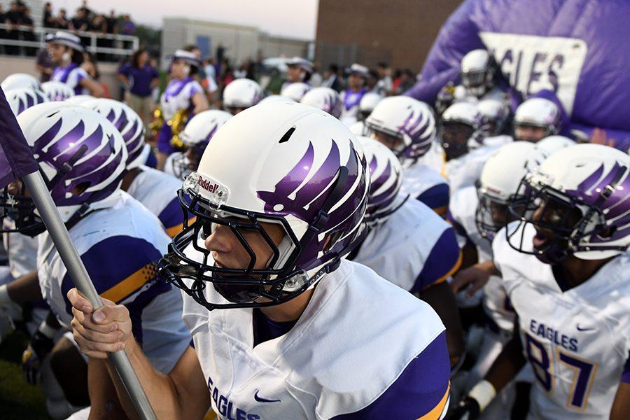 Senior Case Ritter leads the team onto the field, unveiling the new helmet design. Photo by Chad Byrd