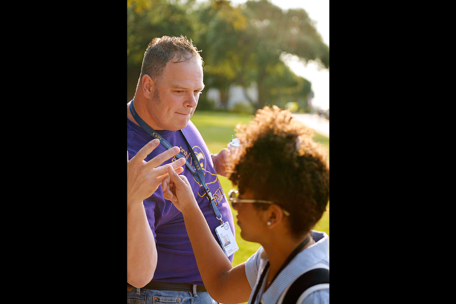 Junior Yasmine Williams and social studies teacher Jared Clem exchange a fist bump as students arrived to school Friday morning. Talon photo by Daphne Lynd