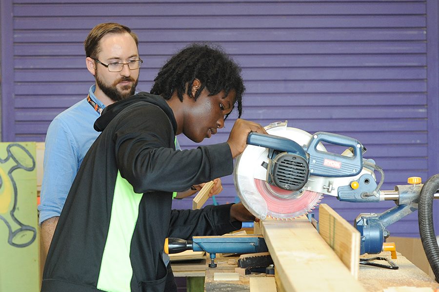 While tech theater teacher Donny Covington watches, junior Payton Fondren-Jones uses a radial arm saw in tech theatres workshop. The workshop was expanded and updated over the summer. Talon Photo by Alauldin Alhaddad