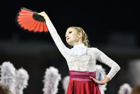During the bands halftime show “Danza De La Rosa” which was thought of last year when sophomore Brian Gary would dance to salsa music every morning, freshman Kiran Scarth strikes a pose. This was the first year colorguard used handheld props other than flags in their performance. Talon photo by Daphne Lynd
