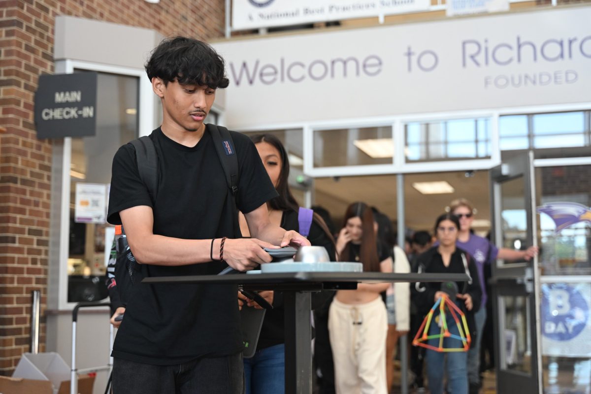 Junior Afraz Islam reaches to unlock his pouch at the front entrance while on his way out of school. 
Photo by Ray Brosnahan