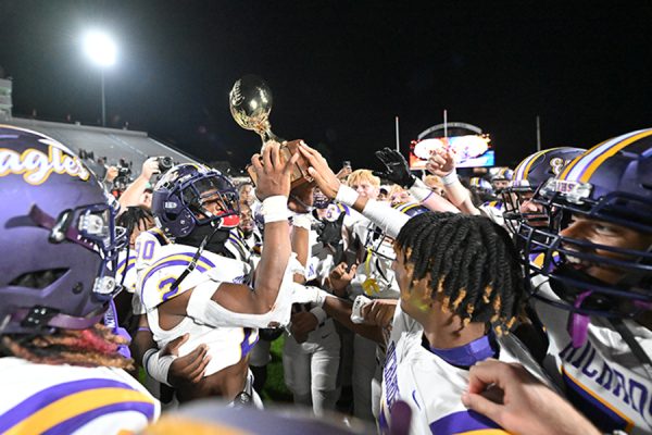 After defeating Haltom High School 28-19 in the first round of the playoffs, Miles Buckley raises the 6A-1 bi-district championship trophy. Talon Photo by Henry Fair