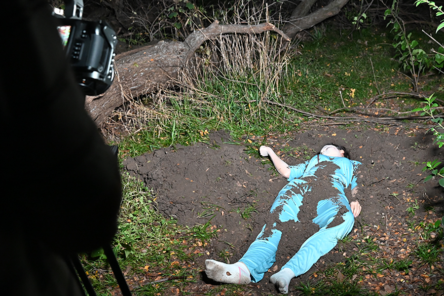 Senior Rebecca Crasneanu lies on the ground, covered in dirt to shoot a scene for the Weekend Race. Talon Photo by Jordyn McCloud