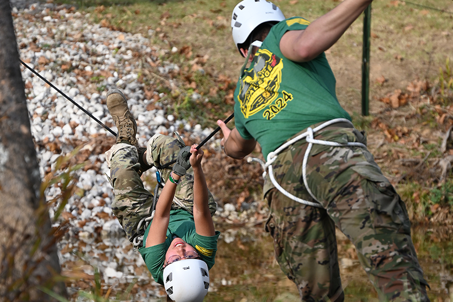 Senior Jaslene Guevara reaches the end of the rope bridge while participating in the 'one rope bridge' challenge at the second annual Raiders Competition in Fort Knox Kentucky. Talon Photo by Ray Brosnahan.