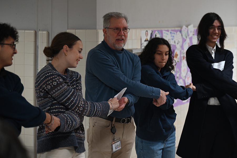 AP Literature and humanities teacher David Townsend joins hands with his students as they recite "Auld Lang Syne", a poem often sung for New Year's. Talon Photo by Xaviar Sheehan.