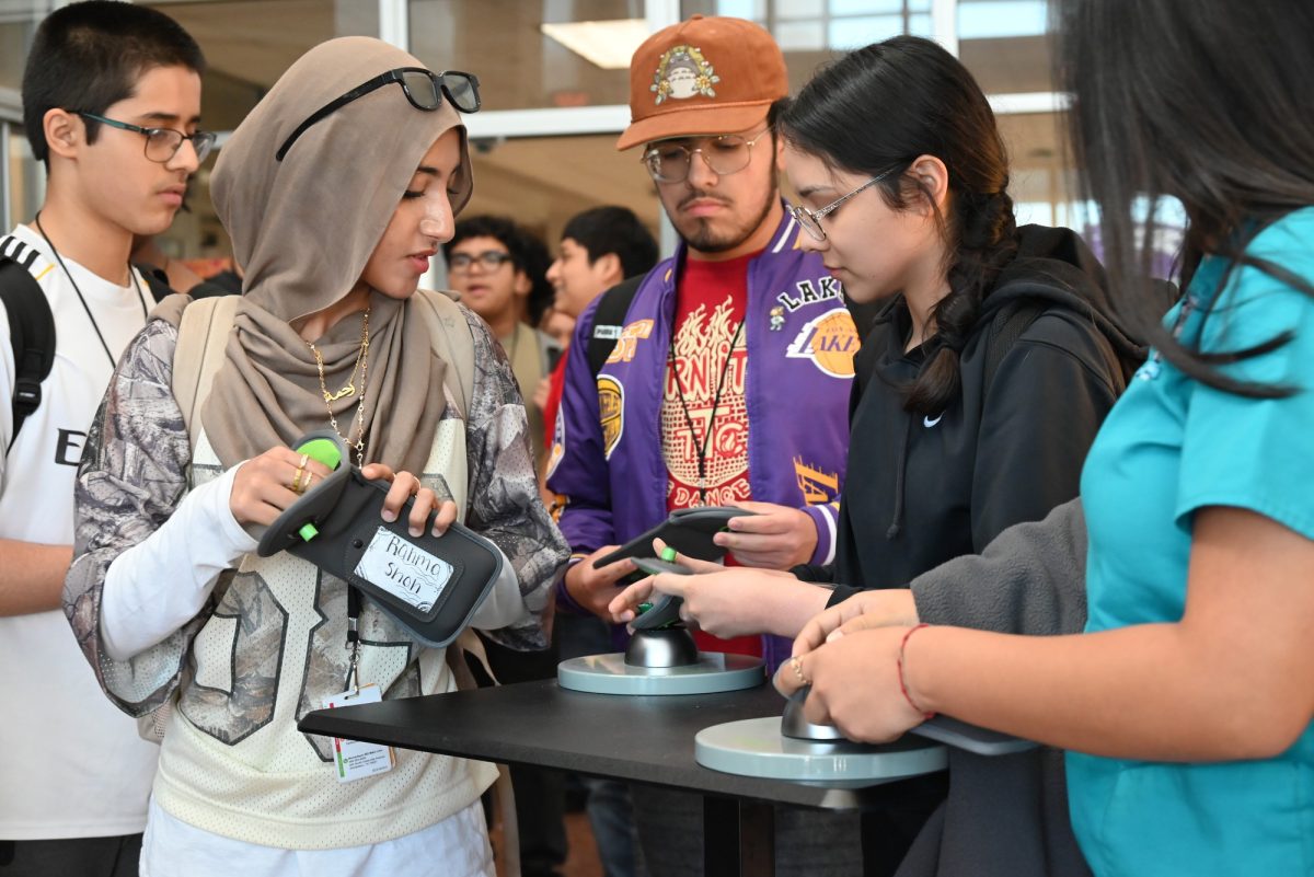 Sophomore Rahma Shah and other students unlock their Yondr pouch as they leave school. Talon photo by Ilan Ahmed.