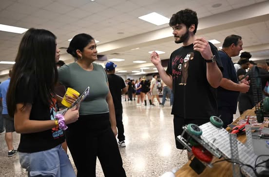 Junior Aidan Dubuclet speaks to an incoming freshman about the RHS robotics program. Talon photo by Henry Fair.