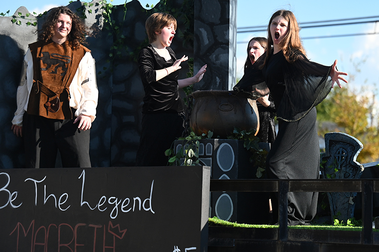 Freshman Aviva Schindler plays one of the three witches alongside two cast mates, while junior Reiner Grantham plays Macbeth on the Theatre Collective’s homecoming parade float. The float they ended up designing was “Be the Legend Macbeth” to promote their upcoming fall show of Macbeth. Talon photo by Ray Brosnahan