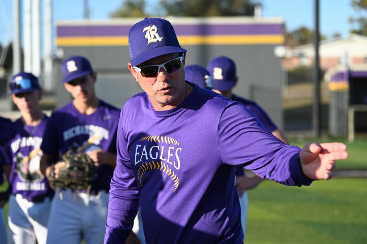 New Head Baseball coach Jason Smiga talks to the varsity baseball team during practice. After 27 years as an assistant coach, Smiga took the reins as the head coach. “I wanted to kind of go back to the fundamentals,” Smiga said. “Teach the fundamentals, and make sure that once they grasp those, then we can get better specific skills.” Talon Photo by Jasper Ngokwere