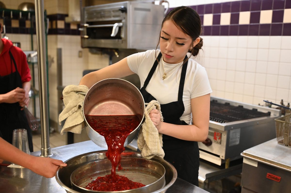 Sophomore Jimena Flores cooks alongside her classmates for the Grab and Go lunch program. After being discontinued last year, Culinary Magnet juniors and sophomores are participating in the Grab and Go once a month to gain hands-on experience in the food industry. Talon photo by Victoria Nwosu