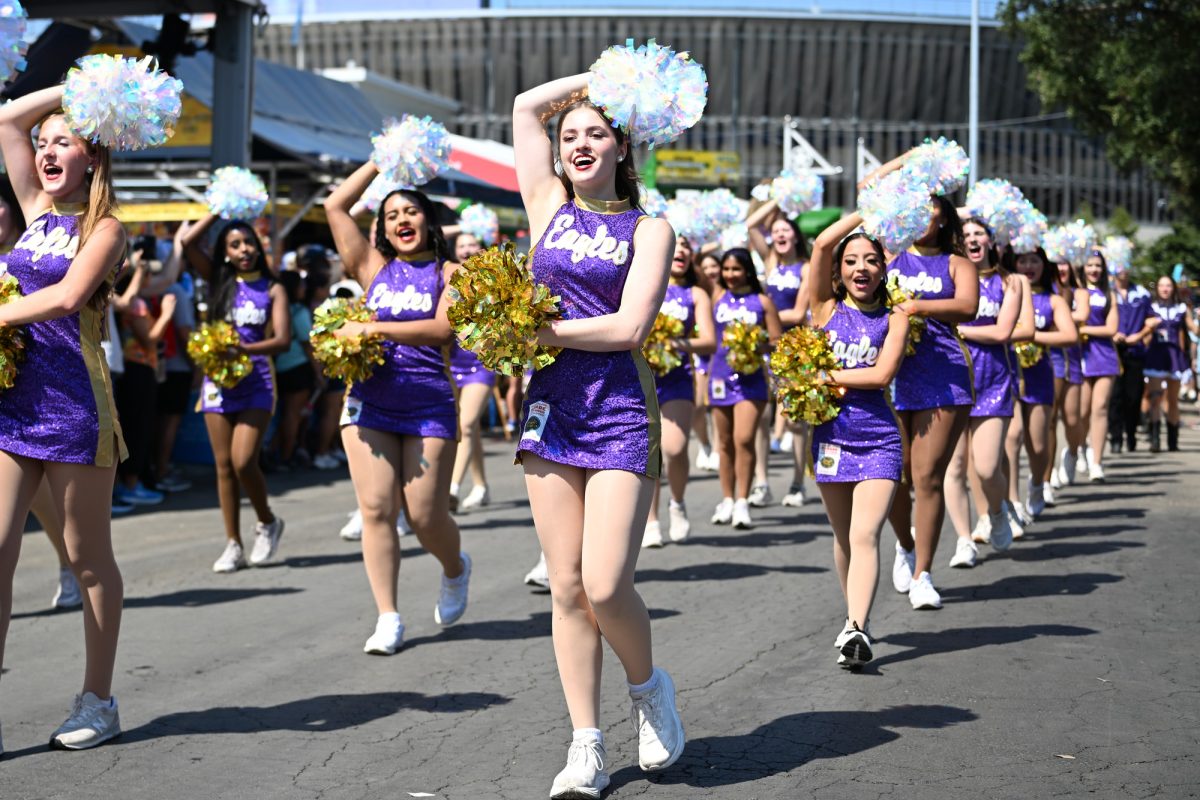 Eaglettes junior Harper Roberts marches down the midway along with the rest of the Eaglettes during the Opening Day Parade of the Texas State Fair. The Eaglettes were the only high school drill team given the opportunity to perform at the parade to kick off the fair. Talon photo by Ray Brosnahan