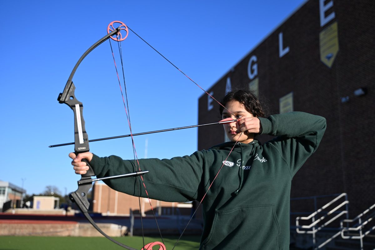 Junior Cadet Jolie Bowden aims her bow and arrow to the target during archery practice. The Junior Reserve Officers' Training Corps (JROTC) introduced a new archery program this year and created an archery team called the Golden Arrows of Eagle Battalion. The team consists of 24 students, divided into two teams: Alpha and Bravo. Talon photo by Henry Fair