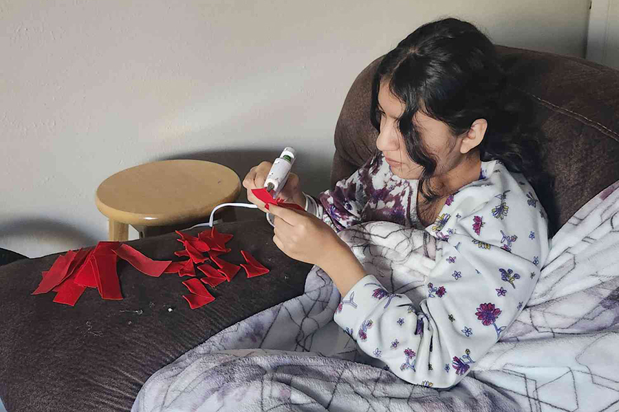 Shivani Ramirez glues ribbon together for an order of her homemade heart bouquets. Ramirez started selling homemade heart bouquets in October to spread her inspiration of making gifts for her loved ones. "I had so much time off my hands that I wondered what if I could make homemade gifts and said something like specifically made for me and just like give it to them," Ramirez said. Photo courtesy by Shivani Ramirez