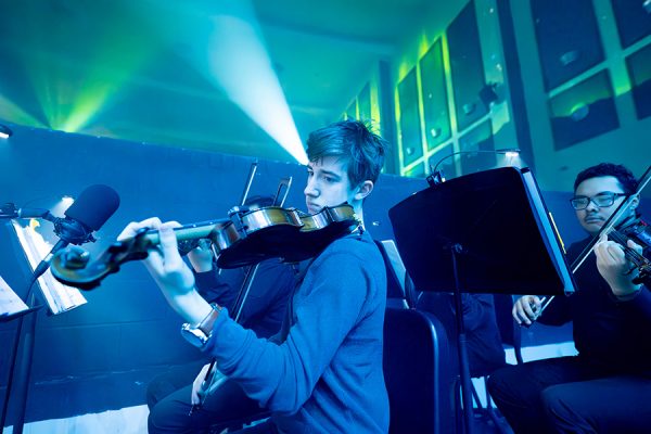 Sophomore NathanCrawford plays his violin in the auditorium pit. Orchestra played in the pit during the Theatre Collective's version of "Frozen" the musical. “I had so much fun" Crawford said. "It was so worth it. I'm going to do it again next year." Talon Photo by Henry Fair